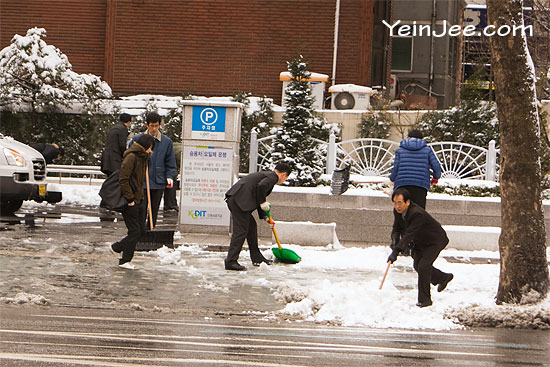 Office workers cleaning snow in Seoul